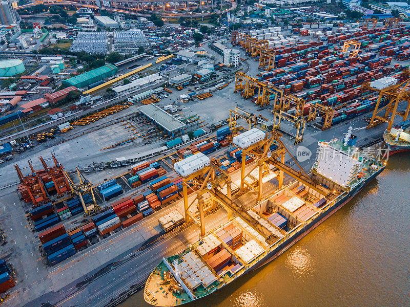 位于泰国曼谷的Klong Toei地区的曼谷港口码头，近距离吊车堆放集装箱箱和货船。